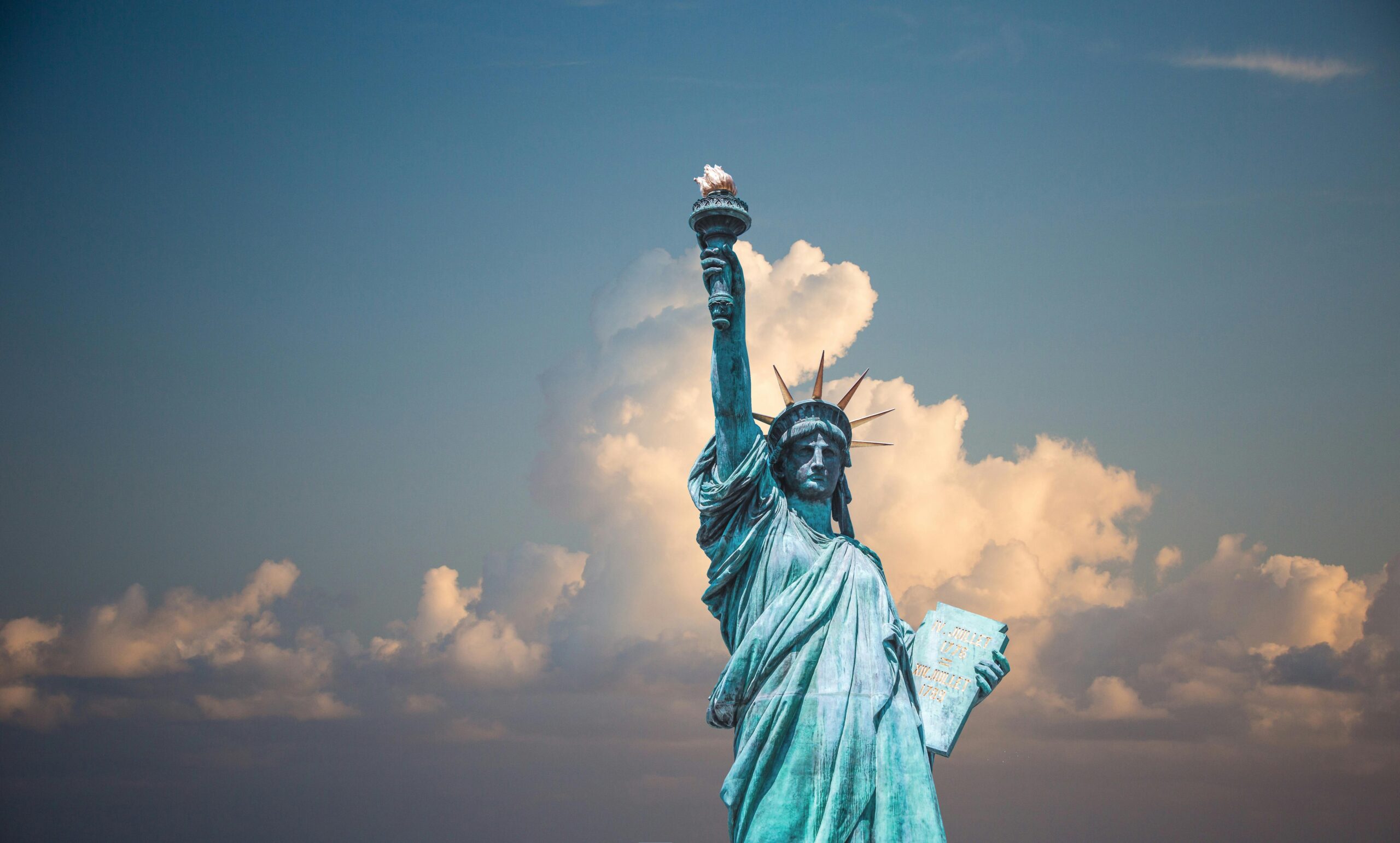 Iconic Statue of Liberty with majestic clouds in New York, USA. Perfect travel destination image.